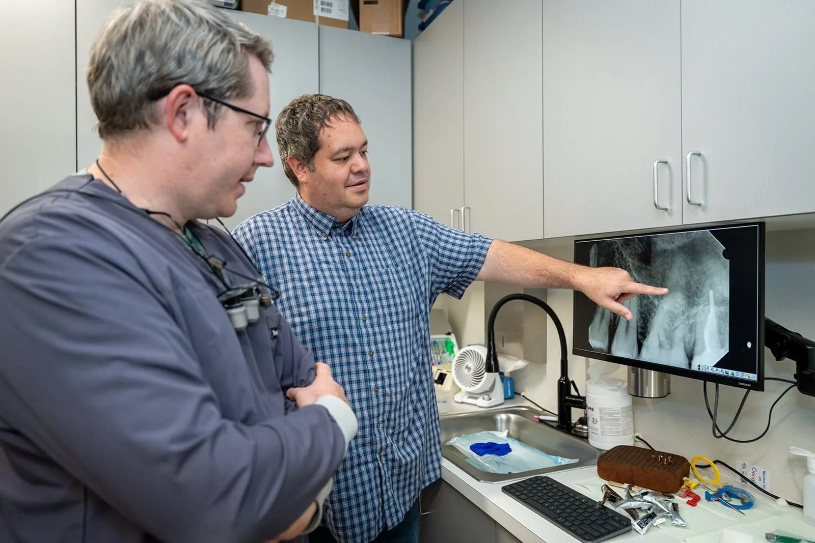 Ryan reviewing an X-ray with a colleague in one of his practices